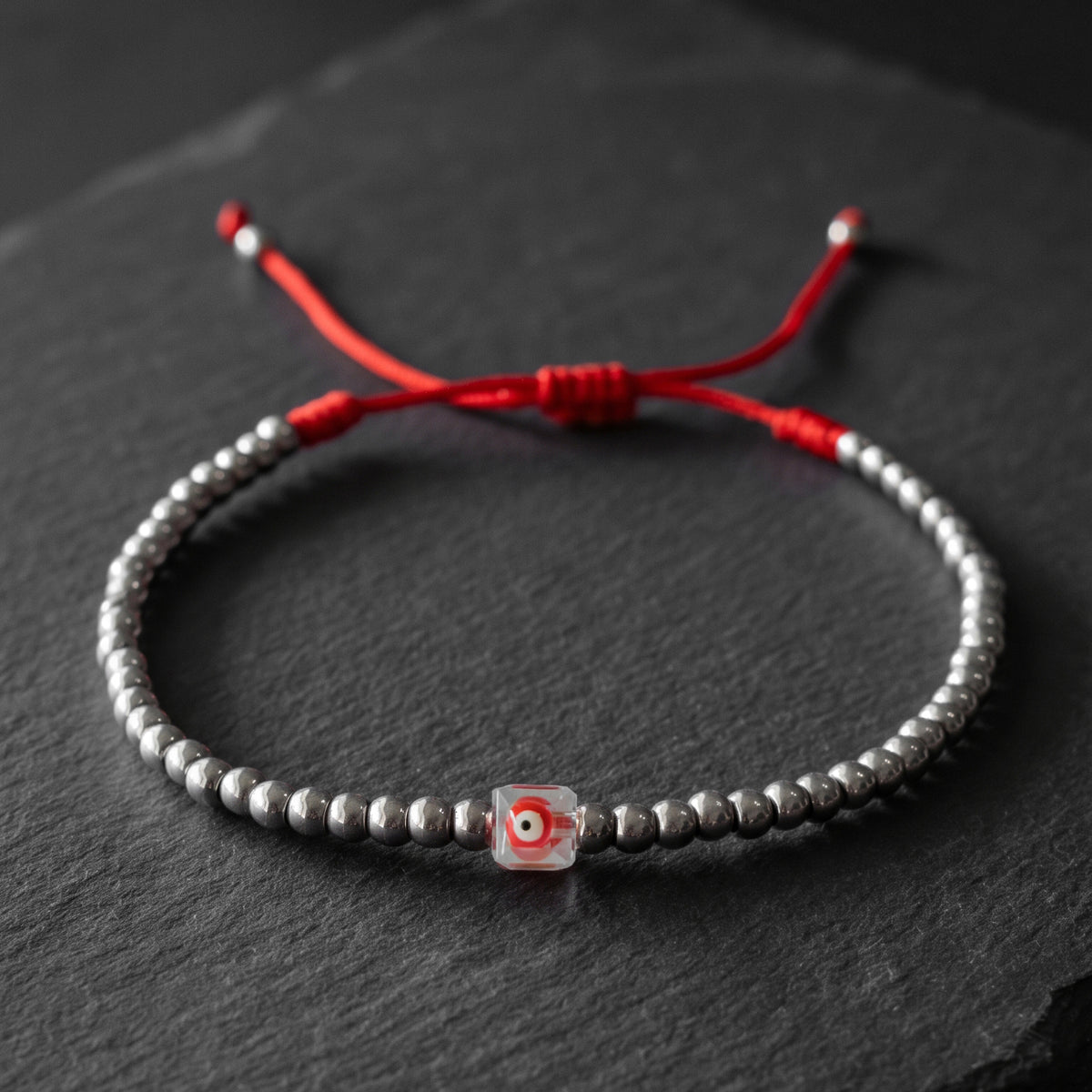 LUCKY CHARM. PULSERA DE ACERO INOXIDABLE CON OJO ROJO CUADRADO CRISTAL
