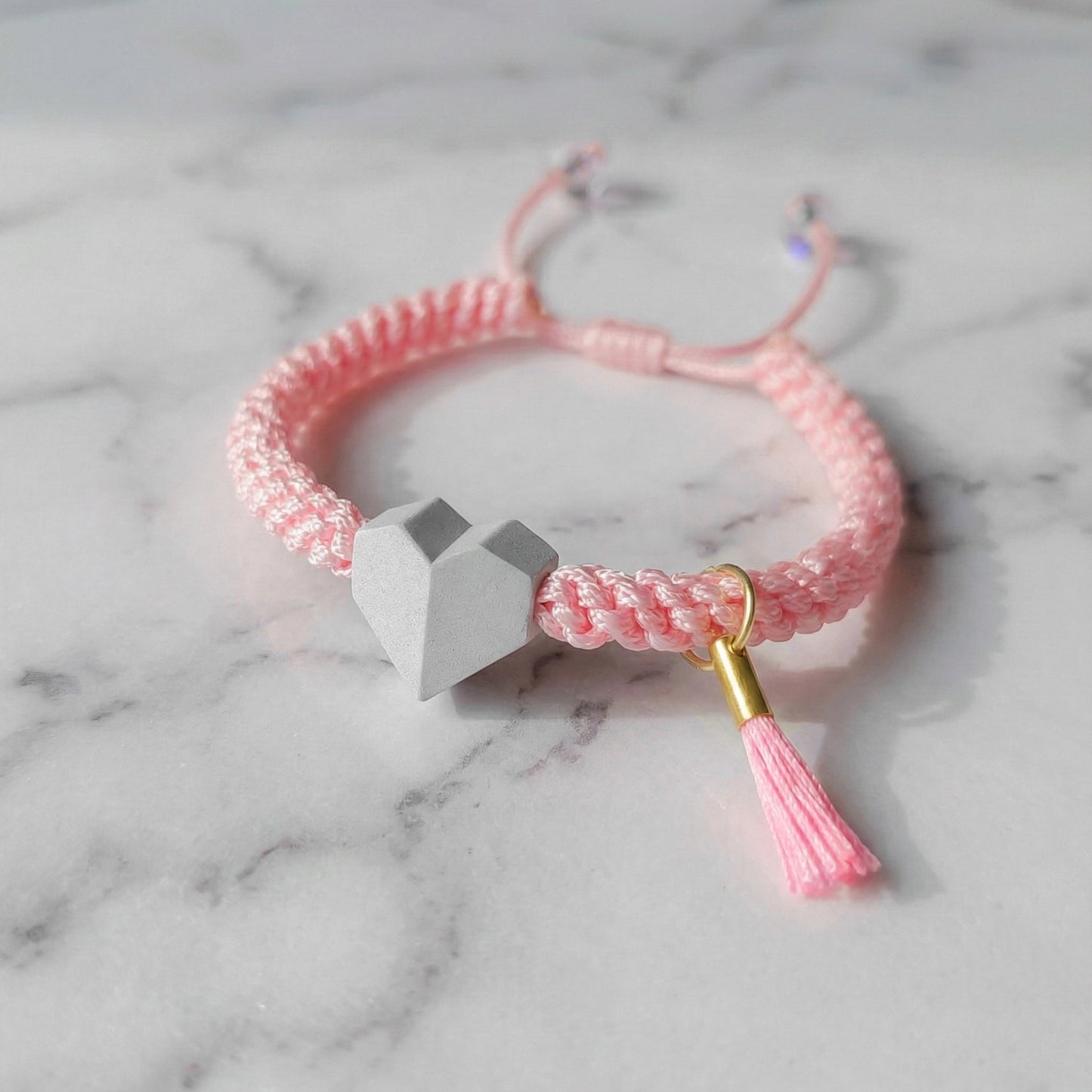 TINY LOVE. PULSERA CON CORAZON Y CORDON TRENZADO ROSA PASTEL